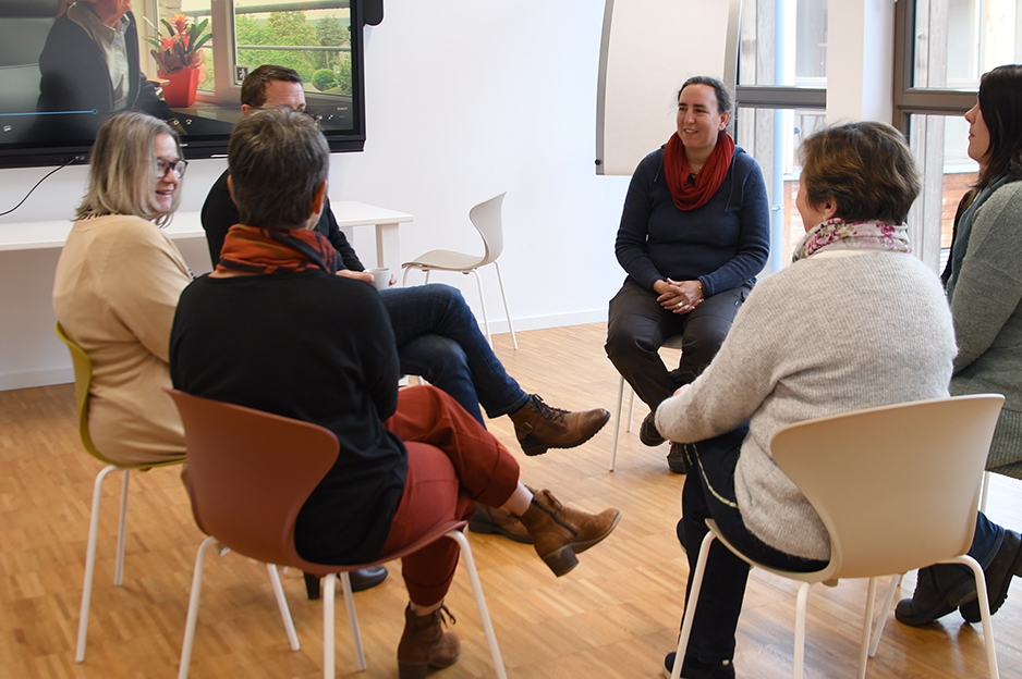 Photo d'un groupe de personne qui débrief